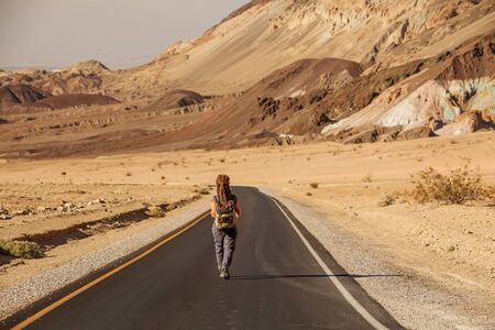hitchhiker woman walking on a road in USAの写真素材
