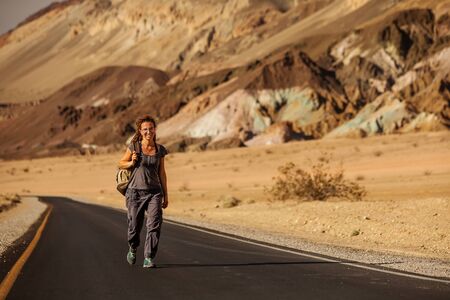 hitchhiker woman walking on a road in USAの写真素材