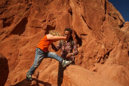 Mom and her son climbing rocksの写真素材