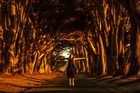 Happy girl in a tunnel with treesの写真素材