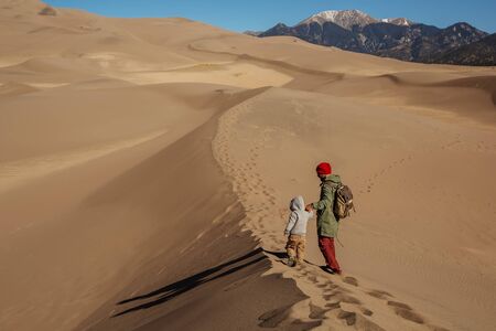 A man with his son are hiking in desertの写真素材
