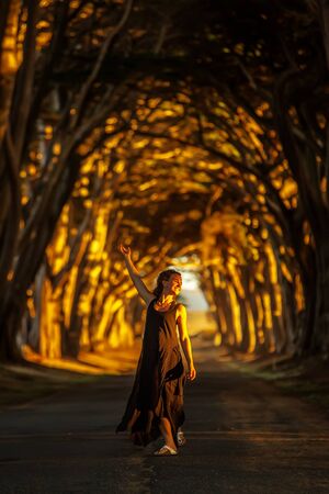 Happy girl in a tunnel with treesの写真素材
