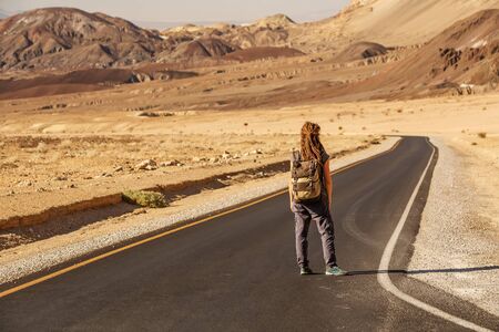 hitchhiker woman walking on a road in USAの写真素材