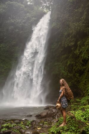 Woman near Nung Nung waterfal on Bali, Indonesiaの写真素材