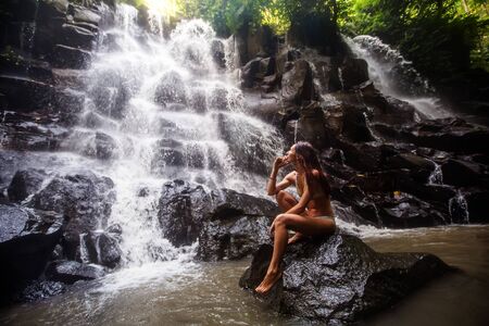 Woman near waterfal on Bali, IndonesiaÂ の写真素材