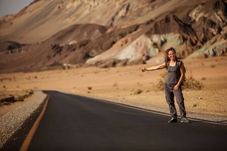 hitchhiker woman walking on a road in USAの写真素材