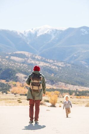 A man with his son are hiking in desertの写真素材