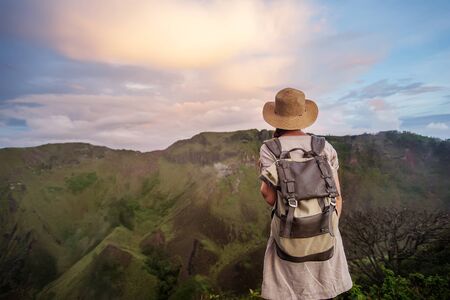 Woman enjoying sunrise from a top of mountain Batur, Bali, Indonesia.の写真素材