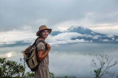 Woman enjoying sunrise from a top of mountain Batur, Bali, Indonesia.の写真素材