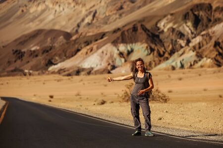 hitchhiker woman walking on a road in USAの写真素材
