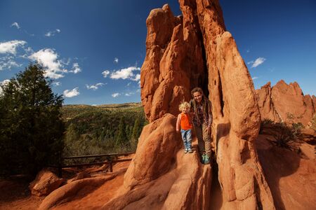 Mom and her son climbing rocksの写真素材