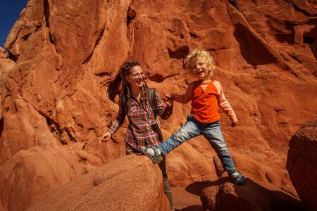 Mom and her son climbing rocksの写真素材