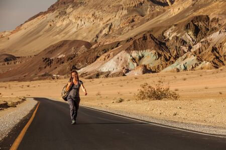 hitchhiker woman walking on a road in USAの写真素材