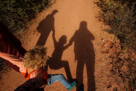 A man with his son are hiking in mountainsの写真素材
