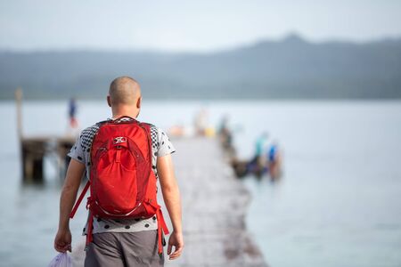 Man at the pier of Pulau Kri island, Raja Ampat Regence, Indonesiaの写真素材