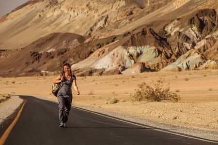 hitchhiker woman walking on a road in USAの写真素材