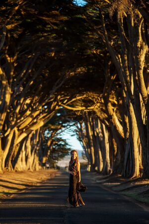 Happy girl in a tunnel with treesの写真素材