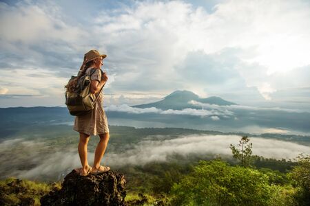Woman enjoying sunrise from a top of mountain Batur, Bali, Indonesia.
の写真素材