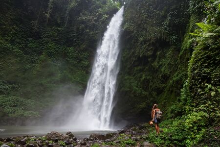 Woman near Nung Nung waterfal on Bali, Indonesiaの写真素材