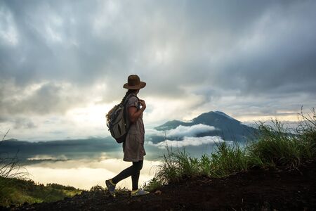 Woman enjoying sunrise from a top of mountain Batur, Bali, Indonesia.
の写真素材