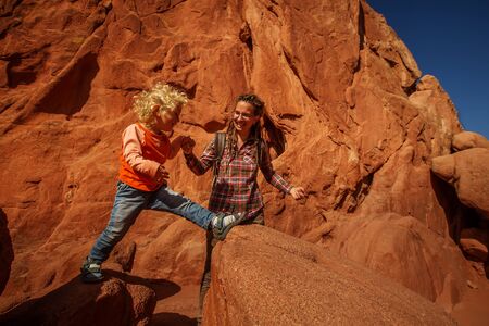 Mom and her son climbing rocksの写真素材