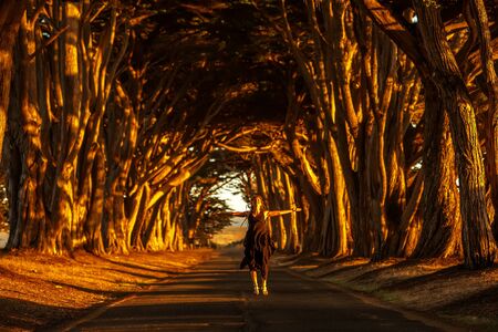 Happy girl in a tunnel with treesの写真素材