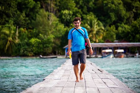 Man at the pier of Pulau Kri island, Raja Ampat Regence, Indonesiaの写真素材