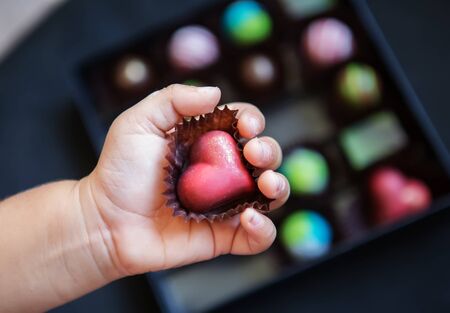 Chocolate heart in the handles of a childの写真素材