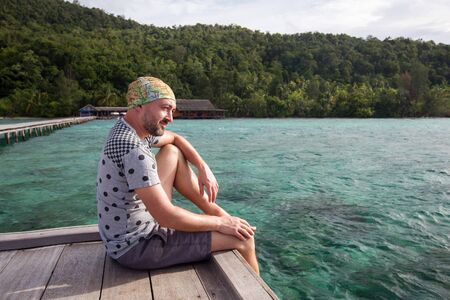 Man at the pier of Pulau Kri island, Raja Ampat Regence, Indonesiaの写真素材
