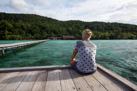 Man at the pier of Pulau Kri island, Raja Ampat Regence, Indonesiaの写真素材