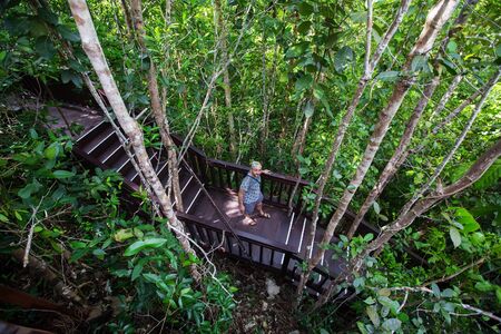 Man of the steps to the top of viewpoint of Piaynemo island, Raja Ampat, Indonesiaの写真素材