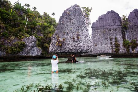 Tourists at the Yapap rock formation, Misool region, Raja Ampat South, Papua, Indonesiaの写真素材