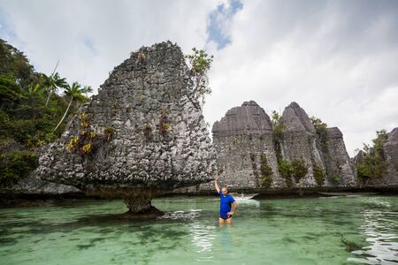 Tourists at the Yapap rock formation, Misool region, Raja Ampat South, Papua, Indonesiaの写真素材