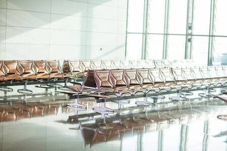 Empty chairs in the departure hall at airportの写真素材