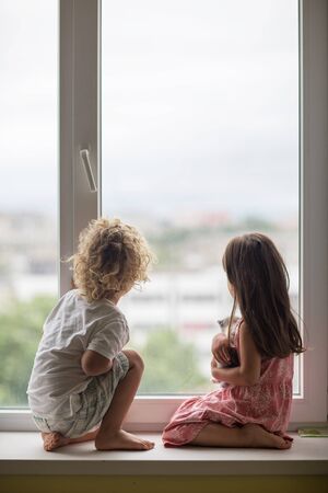 Brother and sister play with a catの写真素材