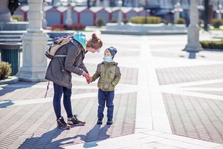 Mother and her son outdoor wearing masksの写真素材