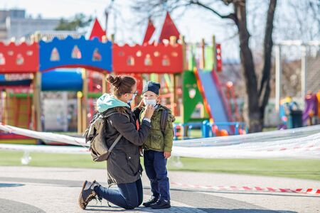 Mother and her son outdoor wearing masks near playgroundの写真素材