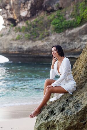 Beautiful woman by the ocean at sunsetの写真素材