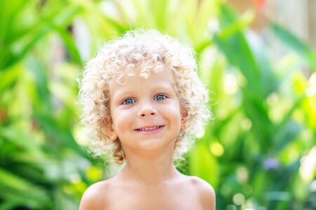 Portrait of a curly white boy in the parkの写真素材