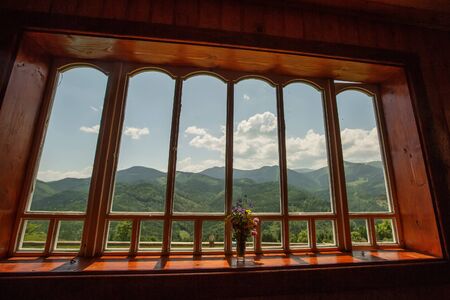 Summer field and mountains seen through the windowの写真素材