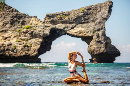 Woman practices yoga at seashoreの写真素材