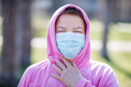 Senior woman wearing mask outdoorの写真素材