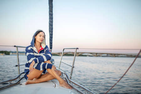Beautiful girl resting on a yacht at sunsetの写真素材