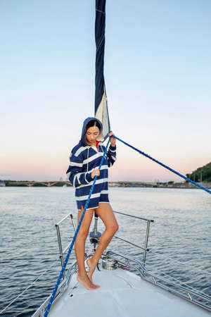 Beautiful girl resting on a yacht at sunsetの写真素材