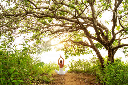 Woman practicing yoga at sunsetの写真素材