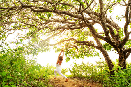 Woman practicing yoga at sunsetの写真素材