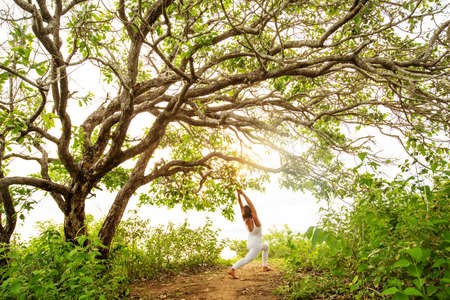 Woman practicing yoga at sunsetの写真素材