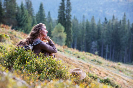 Woman hiker resting after climbing at sunsetの写真素材