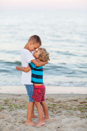 two brothers hugging by the seaの写真素材