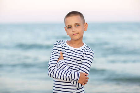 Portrait of a boy at sunset by the seaの写真素材